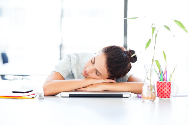 Businesswoman Sleeping On Laptop At Office Desk