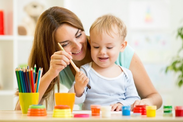 mom and kid boy paint together at home