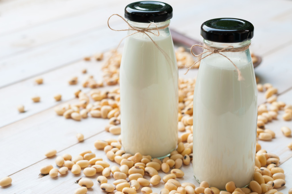 Soy milk in  glass bottle with soy pods